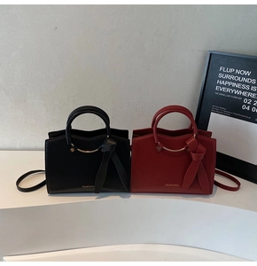 Vue détaillée de sacs cabas rouges et noirs avec poignées dorées et nœuds en cuir chic