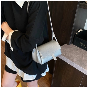 Silver-grey lychee grain leather crossbody bag shown on a model for size perspective