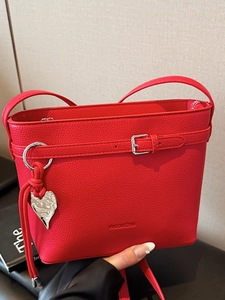 Borsa a secchiello rossa con trama litchi, ciondolo a cuore e tracolla sottile