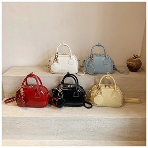 Collection de cinq sacs à main Boston colorés sur des marches en pierre épurées