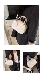 Détail du sac à main crème verni avec pendentif tressé et poignées de transport chic