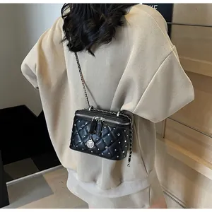 Quilted black leather crossbody bag with silver studs and chain strap on a model