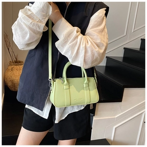 Detail of light green leather handbag with fine texture, arc handle and metallic zipper