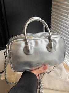 Modern silver metallic baseball-shaped handbag with top handle and fine chain strap