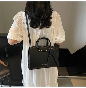 Fashionable black large capacity tote bag with ring detail and adjustable shoulder strap