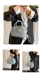 Vue détaillée d'un sac bandoulière bleu clair avec double poignée et fermeture éclair