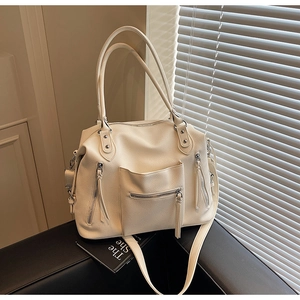 Close-up of cream-white litchi grain tote bag with functional zippers and long handles