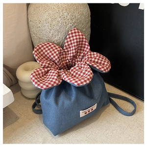 Detail of cute denim flower drawstring bag with red checkered petals and strawberry patch