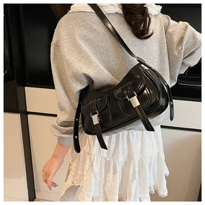 Dettaglio della borsa a spalla in vernice nera con doppie tasche frontali con fibbia elegante