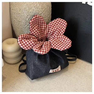 Detail of denim drawstring bag with red gingham lining and white 'YES HONEY!' woven label
