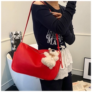 Red PU leather underarm bag with cute teddy bear pendant shown on model in casual setting