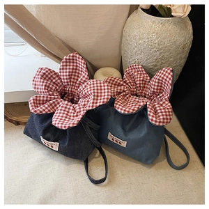 Detail of denim mini drawstring bag with gingham trim and Yes Honey strawberry patch