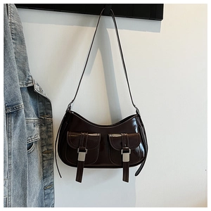 Dettaglio della borsa hobo in vernice marrone scuro con fibbie d'argento e tasche frontali