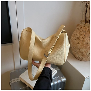 Close-up of cream leather shoulder bag showing soft pebbled texture and silver buckle detail