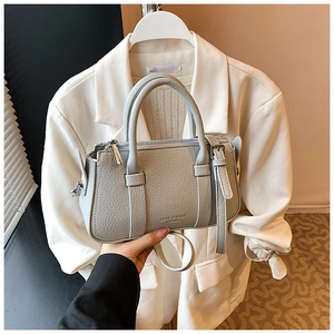Detail of light blue lychee pattern leather handbag with adjustable strap and handles