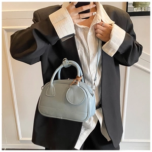 Sac à main bleu clair en similicuir porté avec un blazer noir et une chemise blanche