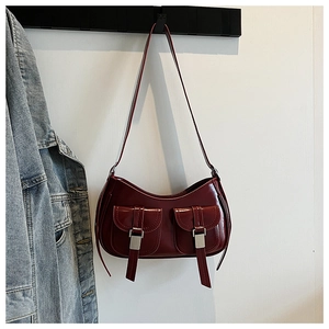 Dettaglio della borsa sottobraccio in vernice bordeaux con doppie tasche anteriori