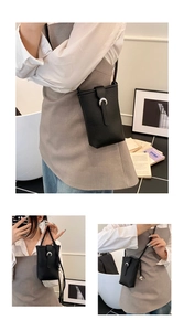 Gros plan sur un sac de téléphone en cuir noir avec boucle fer à cheval argentée