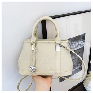 Detail of lychee textured leather handbags with heart charm and silver metal hardware