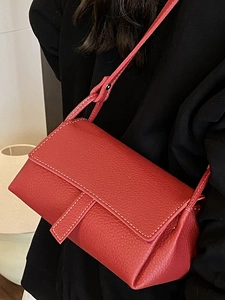 Elegant red litchi texture pillow bag with white contrast stitching and shoulder strap