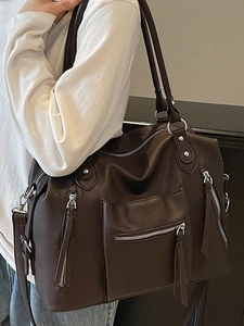 Vintage brown leather tote bag with silver zippers and tassels for stylish women