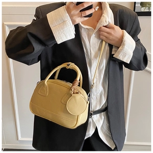 Détail du sac à main jaune avec nœud et petit porte-monnaie assorti sur mannequin chic