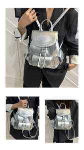 Détail d'un sac à dos argenté métallisé avec boucle et poches latérales