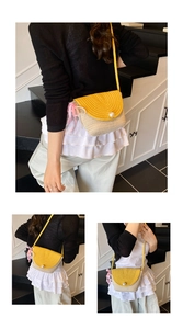 Detail of woven straw crossbody bag featuring lemon yellow flap and pearl buckle