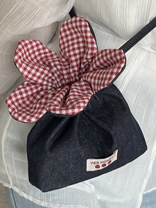 Cute floral denim crossbody bag with drawstring closure and strawberry label design