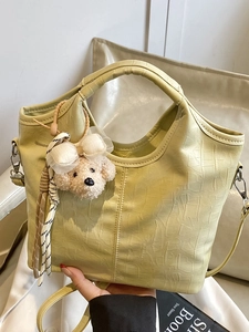 Hellgrüne Handtasche mit Krokodilprägung, Eimerform und niedlichem Bärenanhänger