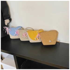 Detail of woven straw crossbody bags in four colors with pearls and pink checkered bows