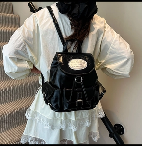 Détail d'un sac à dos noir brillant avec cordon de serrage et boucles métalliques