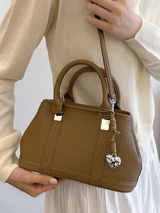 Brown lychee leather handbag with silver hardware and heart pendant accessory