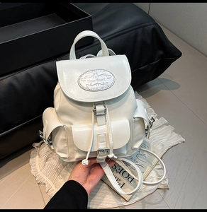 Détail du sac à dos en similicuir crème avec boucles argentées et cordon de serrage