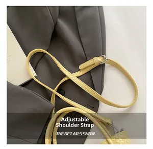 Close-up of yellow textured shoulder strap with silver adjustable buckle and metal clasp