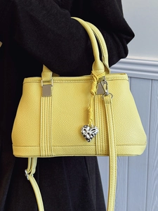 Litchi pattern yellow crossbody bag with silver heart pendant and adjustable strap
