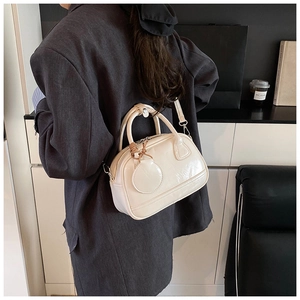 Sac Boston chic en cuir verni blanc cassé avec doubles poignées et bandoulière réglable