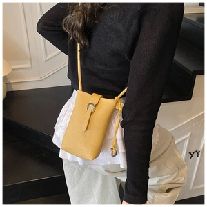Détail d'un sac à bandoulière jaune vif pour téléphone avec boucle fer à cheval argentée