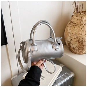 Macro shot of silver cylindrical bag showing metallic leather texture and fine stitching