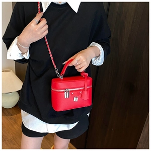Detail of red litchi texture vanity bag with silver padlock and chain strap