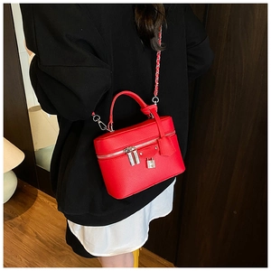 Detail view of red lychee pattern crossbody bag with chain strap and top handle