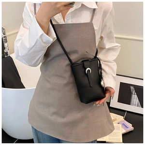Vue détaillée du sac bandoulière en cuir noir avec boucle argentée en forme de croissant