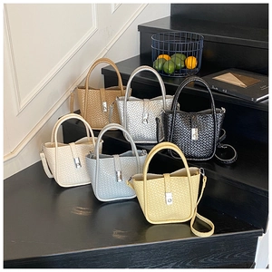 Group display of woven bucket bags in six colors with metallic twist locks