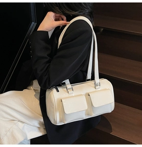 Detail of off-white glossy leather shoulder bag with utility pockets and silver hardware