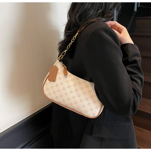 Detail of printed crescent bag with leather trim and gold chain on model's shoulder