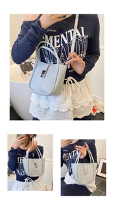 Detail showing the woven texture and silver metal twist lock on the grey bucket bag