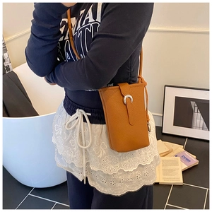 Détail du sac de téléphone en cuir grainé marron avec boucle en métal argenté