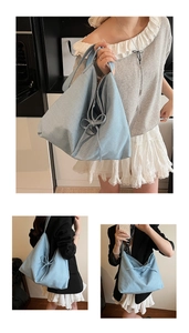 Detail of light blue denim tote bag with decorative bows and sparkling rhinestone accents