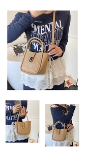 Detail of woven texture bucket bag with silver metal clasp and dual carrying handles