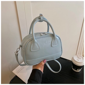 Détails du sac docteur bleu glacier montrant la texture cuir et les poignées rondes